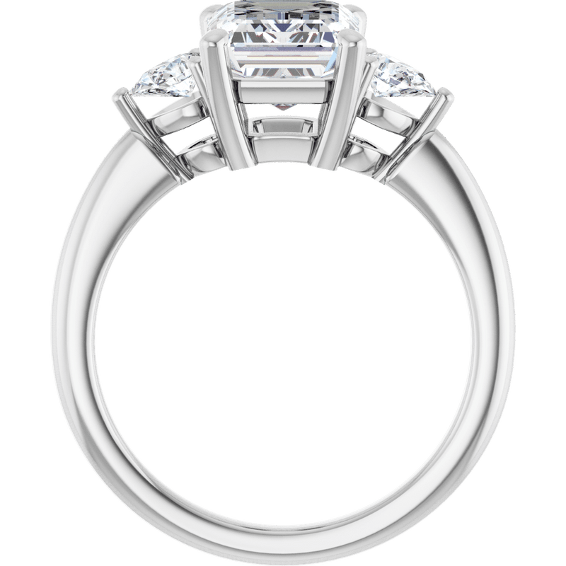 Three-stone diamond engagement ring in white gold with a central emerald cut diamond.