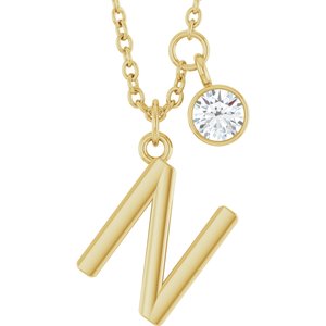 Gold initial N pendant necklace with a sparkling round diamond charm.