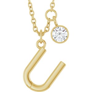 Gold initial J pendant necklace with a sparkling round diamond charm.
