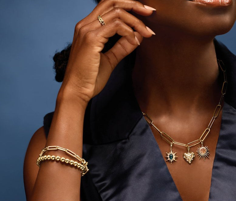 Woman wearing a 14K yellow gold necklace against a blue background