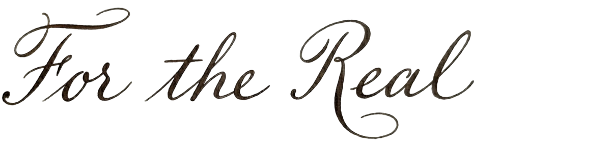 Elegant cursive calligraphy text reading For the Real in dark ink on a white background.