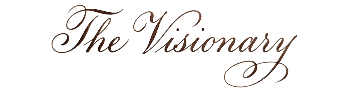 Elegant cursive calligraphy text reading 'The Visionary' in a dark brown script font.