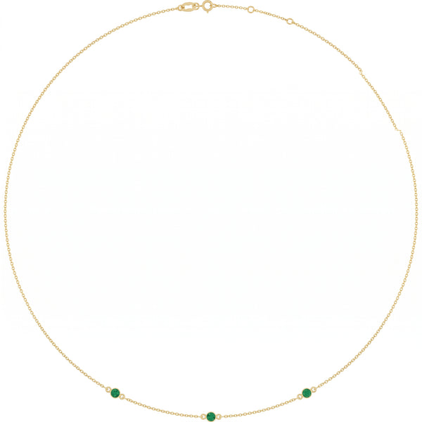 Gold chain necklace featuring three small green emerald gemstones