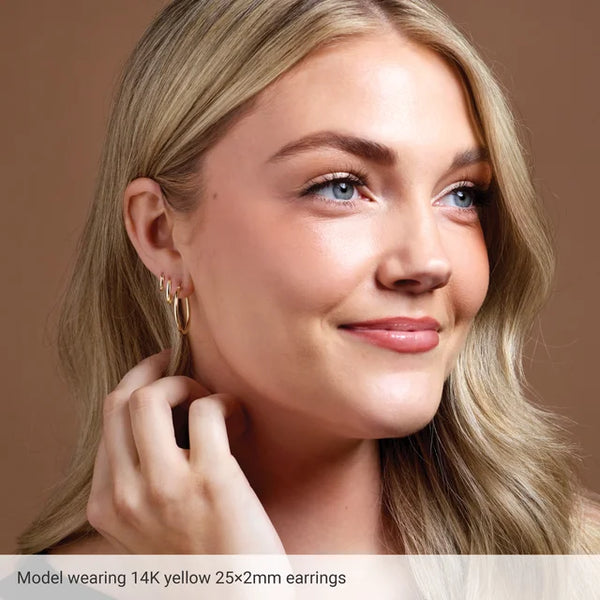 Model wearing 14K yellow gold small hoop earrings.