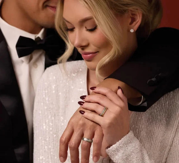 Close-up of a couple wearing 14K yellow gold diamond earrings and wedding rings