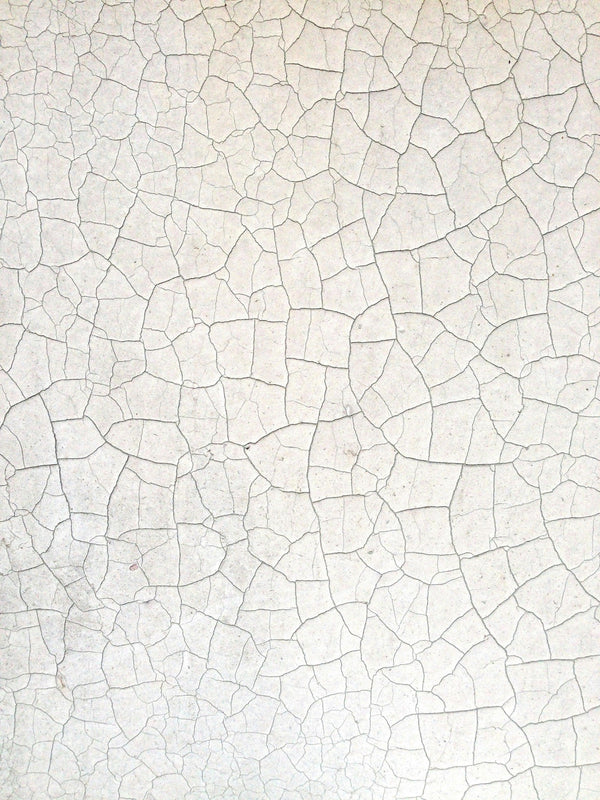 Close-up texture of cracked white ceramic surface with fine mosaic patterns.